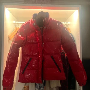 Röd pufferjacka - Säljer en snygg röd pufferjacka som är perfekt för kalla dagar. Den har långa ärmar och två praktiska fickor med dragkedjor. Perfekt för att hålla värmen under vintern🥰 säljer pågrund av att den är förliten. Köpte för 900kr
