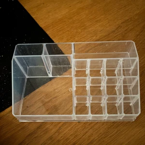 Sminkorganiserare / sminkställ - Praktisk transparent sminkorganiserare med flera fack för enkel förvaring av sminkprodukter. Perfekt för att hålla ordning på läppstift, borstar och andra små tillbehör. Tillverkad i hållbar plast. 8cm x 12cm x 22 cm, nypris 150 