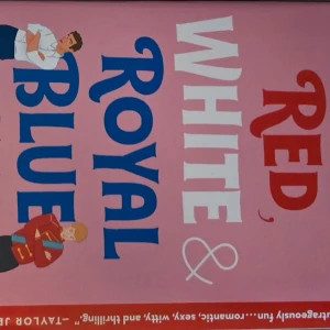 Red, White & Royal Blue - Boken 'Red, White & Royal Blue' har en rosa omslag med stora bokstäver i rött, vitt och blått. Två tecknade figurer står lutade mot texten, en i vit skjorta och en i röd jacka. En romantisk och humoristisk berättelse.