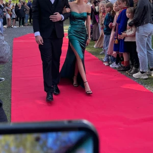 Grön balklänning - Säljer nu min otroligt fina balklänning som jag hade på min killes bal. Den är off shoulder med slits och släp. De är även silikon på insidan över bysten för att den ska hållas uppe. Den är uppsydd längst ner och intagen lite runt bysten men är gjort proffesionellt. Den är från shein men verkligen bra kvalitet. Använd 1 kväll och har nån fläck på släpet, men absolut inget man tänker på. Pris går att diskutera💞