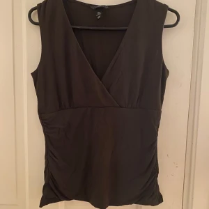 Brun omlettopp  - Söt brun ärmlös topp som sitter fint i midjan. 