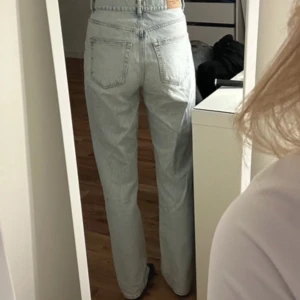 Ljusblå jeans från Gina Tricot  - Säljer ett par ljusblå jeans från Gina Tricot . De har en klassisk straight passform och är högmidja. Längden på modellen 174 cm.Har fläck på sig men det är igt man lägger märke på 