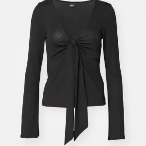 Svart långärmad topp med knyt - Snygg svart långärmad topp från Gina med knyt framtill och v-ringning. Perfekt för en stilren look. Tröja är i storlek S och är bara andvända en gång