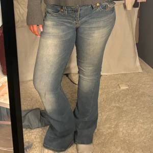 Blå bootcut jeans från True Religion - Snygga blå bootcut jeans från True Religion med klassisk femficksdesign och broderade bakfickor..storlek 29, skriv för fler bilder 💗
