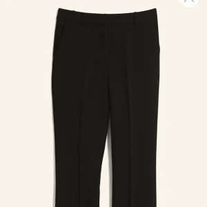 Svarta kostymbyxor - Eleganta svarta kostymbyxor med hög midja och rak passform. Perfekta för en stilren look. Byxorna har diskreta fickor.