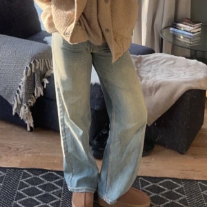 Ljusblå jeans från Nelly - Säljer ett par ljusblå jeans från Nelly. De har en loose fit och är lågmidjade, perfekta för en avslappnad stil. Jeansen har en klassisk design med knapp och dragkedja framtill.