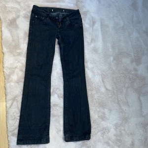 Jätte lågmidjade Svarta jeansbyxor - Snygga svarta jeansbyxor från Only med en bootcut passform. De har en låg midja och är perfekta för en sexig stil. Lappen på byxorna är tyvärr borttagna. Innerbenet 79 cm och midjemått 36 cm.