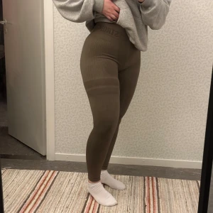 Bruna ribbade leggings från Stronger - Snygga bruna ribbade leggings från Stronger i storlek S. De har en tight passform och är perfekta för träning eller en avslappnad dag. Högmidjade för extra komfort och stil. Passar även M och kanske L.