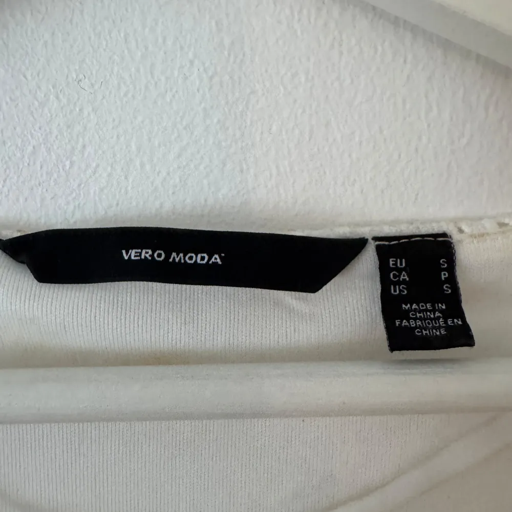 Säljer min fina studentklänning. En vit kortklänning från Vero Moda med v-ringning och trekvartsärmar. Otroligt skön klänning som inte skaver och är perfekt att bära under en hel dag. Klänningen har ett fint broderat mönster och volangdetaljer vid ärmsluten. Perfekt som studentklänning! Jag köpte klänningen för 600kr från Vero Moda och den är endast använd en gång och är i väldigt bra skick!. Mekot.