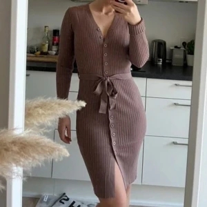 Brun ribbad klänning med knappar - Snygg brun ribbad klänning med v-ringning och knappar framtill.  Kan användas som en cardigan eller klänning, knappt använd💕 Pris går att diskutera vid snabb affär💕