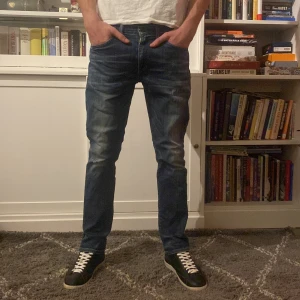 Levi's 511 jeans i blå denim - Snygga Levi's 511 jeans i blå denim med en slim passform. De har en klassisk femficksdesign och en bekväm midwaist. Perfekta för en stilren look.