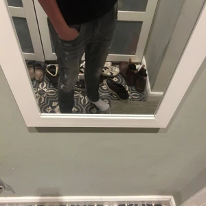 Grå Replay Anbass jeans - Säljer ett par grå Replay Anbass jeans i herrstorlek 32/30. De har en snygg, sliten look med dragkedja och knappdetaljer. Perfekta för en avslappnad stil. Nypris 1800kr (litet hål vid skrevet därav priset) bara höra av sig vid eventuella frågor!