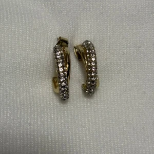 Guldörhängen med glittriga stenar - Snygga guldörhängen med en rad av glittriga stenar som ger en lyxig känsla. Perfekta för att lägga till lite extra bling till din outfit. De har en klassisk design som passar till många tillfällen.
