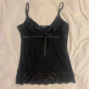 Paljett och spets linne💘 - Ett så fint svart linne med spets och paljetter från Jane Norman⭐️ storlek står ej men skulle uppskatta S men det ör stretchigt så skulle nog även passa M! Tecken på användning i form av lösa trådar finns då de är köpt second hand men knappt använt av mig😽Kanten vid bysten är likadan som nertill med det framkommer inte riktigt på bilderna (näst sista bilden visar baksidan)! 💞det är bara att skriva om du undrar något! 