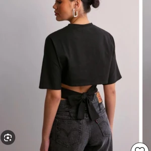 Nelly topp - Populär svart topp från Nelly som man knyter i ryggen, helt ny använd 1 gång! Storlek S. (Spegeln som är smutsig på bilden och inte tröjan)