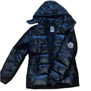 Moncler Himalaya - Säljer en Moncler Himalaya i storlek 3, vilket motsvarar S/36! Jackan är i bra skick men det finns lite defekter. Den har små hål på höger arm, ena Moncler metall-loggan har lossnat på dragkedjan och tvättlappen är lite halvbra, men den går lätt att sy på. Den har ett par år på nacken, det är därför. Men fortfarande riktigt fin, och väldigt varm! Hör av er vid behov av fler bilder eller frågor!