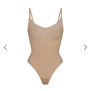 Beige bodysuit från Skims - Säljer en beige bodysuit/shapewear från Skims med smala axelband och en slät design. Perfekt för att skapa en smickrande siluett under kläder. Materialet är mjukt och stretchigt. Helt ny med prislapp!