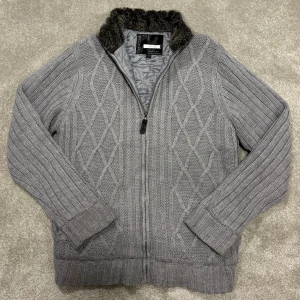 Stickad Cardigan/Kofta med päls - Säljer denna asfeta grå stickade Cardigan med pälskrage och fodring i hela jackan! Cardiganen är grymt skick, inga defekter! Size M, sitter tts. Modellen på bilden är 182cm lång ish. Skriv vid funderingar!