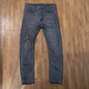 Snygga grå  jeansbyxor med klassisk femficksdesign och dragkedja. Perfekta för en avslappnad stil.  Storlek 30/32