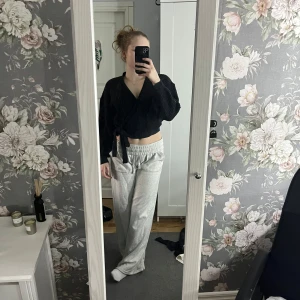 Svart ribbad kofta - Säljer en svart ribbad kofta med knytning framtill. Koftan har en v-ringad design och långa ärmar, perfekt för en stilren look. Passar bra till både jeans och kjol.