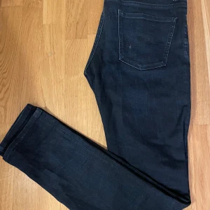 Svarta jeans från J.Lindeberg - Snygga svarta jeans från J.Lindeberg med en klassisk femficksdesign. De är slim fit och är tillverkade i ett bekvämt denimtyg. Perfekta för en stilren look, eller grish look