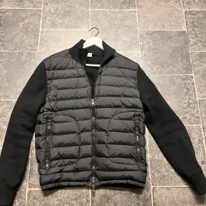 Svart dunjacka från Moncler - Säljer nu min snygga svarta dunjacka från Moncler då den är lite för liten för mig. Jackan har långa ärmar och en ribbad krage. Perfekt för kyligare dagar. Den är i storlek M. Inget og, endast qr kod. Hör av er för frågor eller funderingar!😀