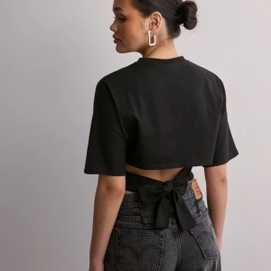 Open Back Tie Tee - Säljer denna väldigt eftertraktade Nelly toppen i storlek xxs. Aldrig andvänd då det inte var rätt storlek för mig , alla lapparna sitter kvar. kontakta mig för flera bilder. (HÖGSTA BUD 400 KR!!!) ❤️