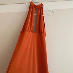 Lång orange klänning  - Jättefin balklänning med urringning och öppen rygg. Fint skick! 