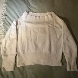 Vit stickad tröja - Säljer en supermysig vit stickad off shoulder tröja som är perfekt för kyliga dagar. Den har en lös passform och långa ärmar, vilket gör den både bekväm och stilren. Tröjan är i bra skick . Perfekt för höst och vinter!
