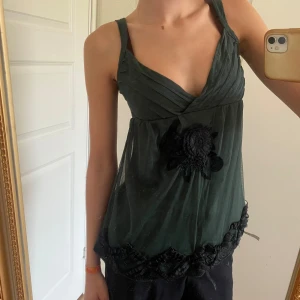 Grön Y2K-topp - Cool grön topp/linne. Har köpt second hand så tyvärr är det några trådar som lossnat längst ner (se sista bild), men går att fixa med ett enkelt stygn!