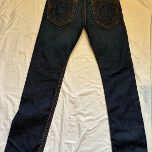 True religion jeans - Rensar min garderob. Säljer nu mina trueys som ja växt ut, storlek 34/34. Modellen är rocco thick stich, små slitage.