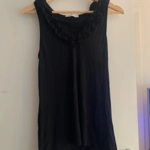 Svart linne med volang  - Fint linne med volanger vid kragen. Använd gärna köp nu! Köparen står för frakten