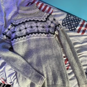 Grå stickad polotröja från High Mountain - Säljer en supermysig grå stickad polotröja från High Mountain. Den har ett snyggt mönster i svart och vitt över bröstet och långa ärmar. 