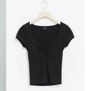 Svart kortärmad topp  - Snygg svart topp från gina med söt scrunch detalj