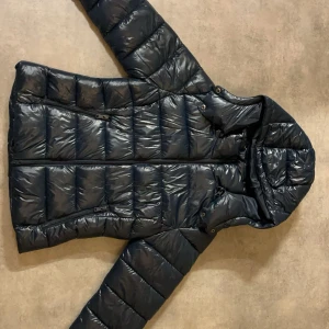 Mörkblå jacka från Lager 157 - Snygg mörkblå jacka från lager 157 i storlek XS. Jackan har en avtagbar huva och praktiska dragkedjor. Perfekt för kyliga dagar med sin quiltade design och långa ärmar. Ett måste för garderoben! Finns inget tagg men aldrig använt.