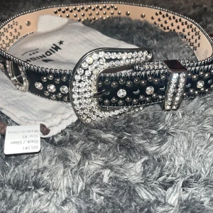 Svart Tuttolente bälte  - Säljer pga använder inte så mycket längre. Storlek XS skriv ifall ni undrar om mått. Ända deffekterna är att 2 småstenar ur hästskorna har ramlat ut försökte ringa in på den sista bilden men man ser knappt. 