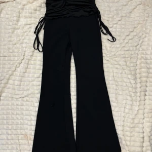 Svarta byxor med knytband - Snygga svarta byxor med vida ben och knytband i midjan. Perfekta för en stilren look. Skriv för fler bilder.