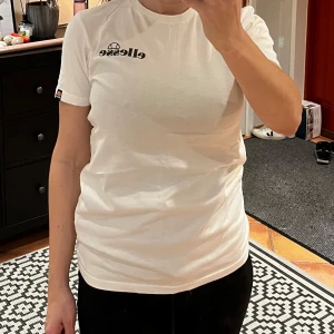 Vit t-shirt från Ellesse - Säljer en vit t-shirt från Ellesse med stort tryck på baksidan. Storlek S