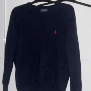 Mörkblå tröja från Ralph Lauren - Säljer en stilren mörkblå tröja från Ralph Lauren med det klassiska röda logotypen på bröstet. Tröjan har långa ärmar och en rund halsringning. Perfekt för en avslappnad och snygg look. Passar s och även m sitter den perfekt! 