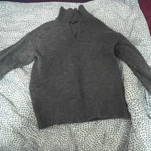 Grå stickad tröja från Esmara - Mysig grå stickad tröja från Esmara med v-ringning och långa ärmar. Perfekt för kyliga dagar med ribbade muddar vid ärmslut och nederkant. En klassisk och bekväm tröja för alla tillfällen.