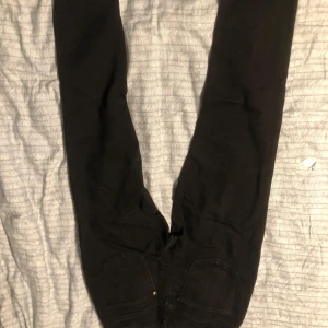 Svarta slim fit byxor från H&M - Snygga svarta slim fit byxor från H&M med justerbar midja. Perfekta för en stilren look. Passar ungdomar i åldern 12-13 år.