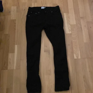 Svarta slimmy jeans från 157 - Snygga svarta slimmy jeans från 157. De har en klassisk design med fem fickor och knappgylf. Perfekta för en stilren look.