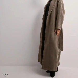 Beige kappa med bälte intresse koll  - Snygg och stilren beige kappa med knytbälte i midjan. Den har en lång och elegant design med långa ärmar och en klassisk krage. Perfekt för att hålla sig varm och trendig under kyligare dagar. Använd vid ett tillfälle !!! Prisförslag mottages gärna 