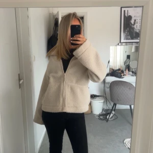 Beige teddyjacka med dragkedja från hm - Mysig beige teddyjacka med dragkedja framtill. Perfekt för kyliga dagar med sin fluffiga och varma design. Jackan har långa ärmar och en avslappnad passform. Str k men passar s-m