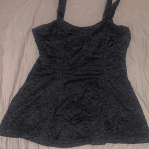 Svart spetslinne - Säljer ett svart spetslinne med breda axelband. Toppen har en elegant design med spetsdetaljer och går ut längst ned💕