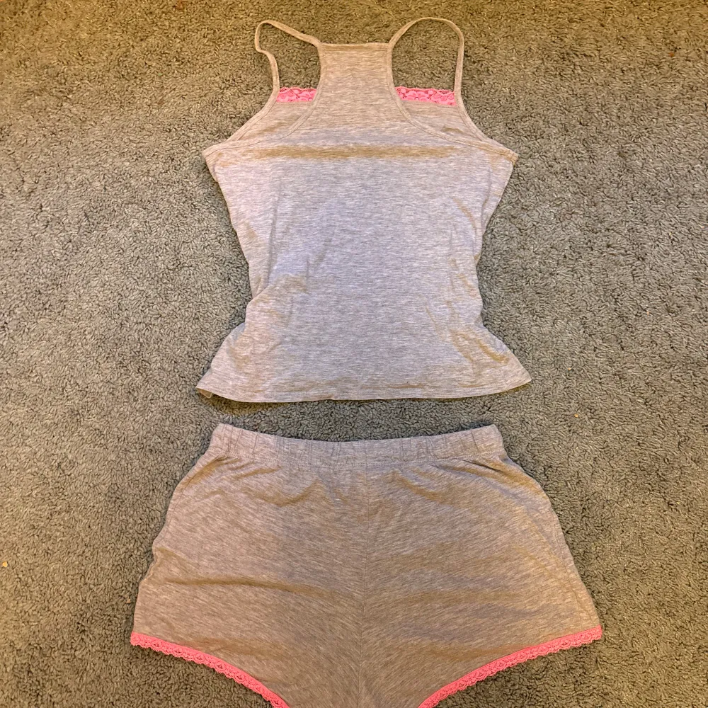Säljer det här supergulliga toppen från H&M med smala axelband och fina rosa spetsdetaljer vid bysten. Matchande shorts med rosa spetskant ingår.Storleken är barn 146-152 men passar även som XS. Använd fåtal gånger därav mycket bra skick. . Yläosat.