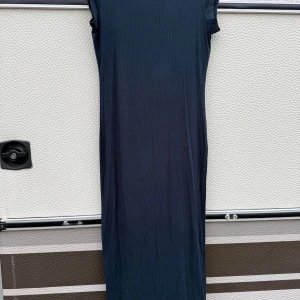 Mörkblå ribbad klänning - Snygg mörkblå ribbad klänning med ärmlös design. Perfekt för en stilren look. Klänningen har en enkel och elegant passform som framhäver figuren.