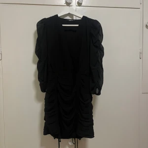 Svart klänning från Ginatricot🥰 - Svart kort klänning från Ginatricot med puffiga ärmar och rynkat material. Lite liten i storleken