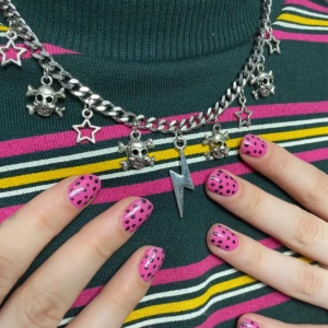Kedjehalsband med dödskallar och blixt - Coolt kedjehalsband med hängande dödskallar, stjärnor och en blixt i silverfärg. Perfekt för att ge en edgy touch till din outfit.