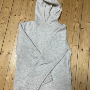 Stickad hoodie - Säljer en stickad hoodie i storlek xs. Den har en beige/grå färg och är i mycket bra skick. Vid frågor är det bara att skriva!